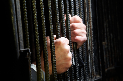 Hands in a jail cell show that fake ID charges in Utah can be serious - call Branson West Law today.