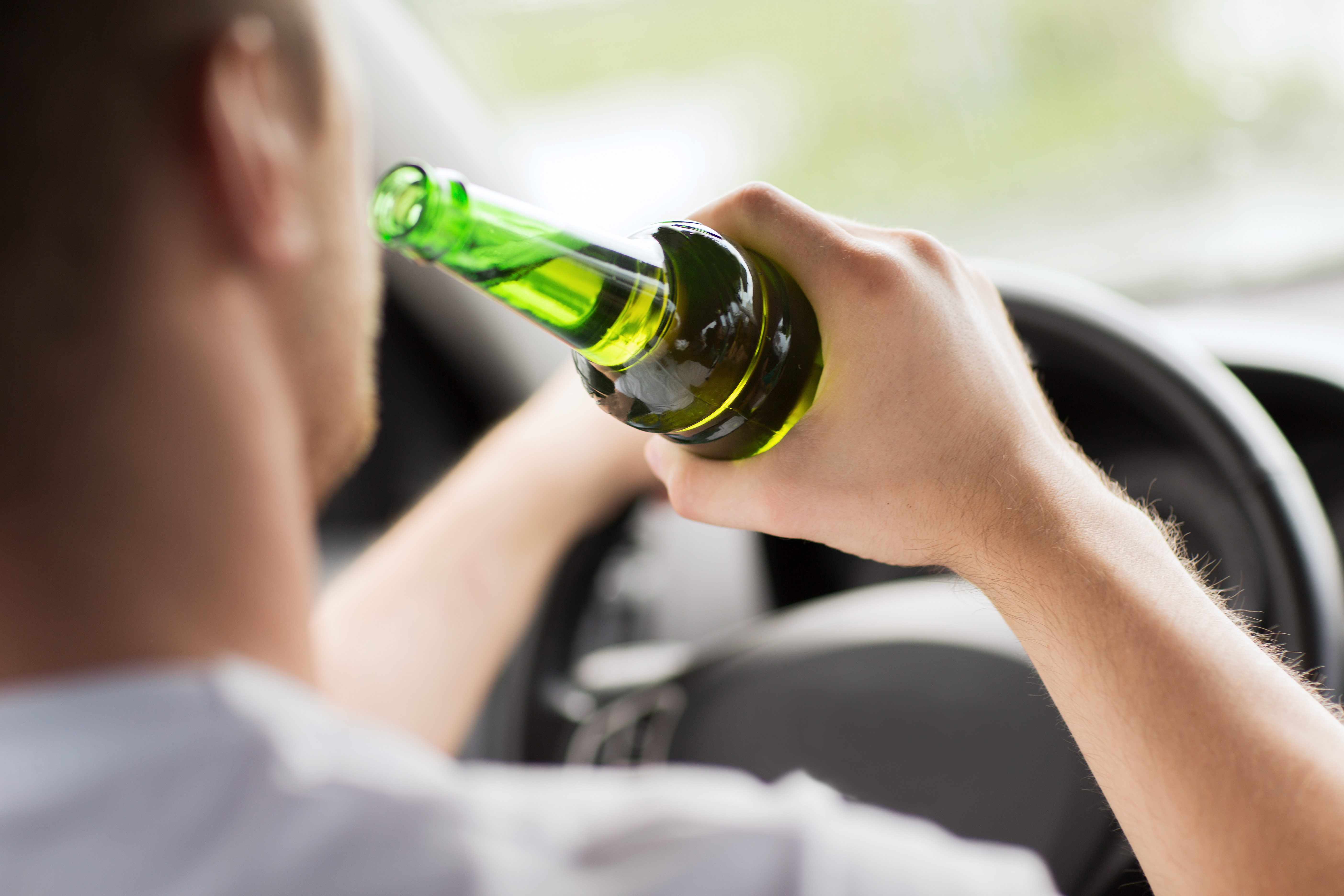 A person drinking in a car - if you need a restricted license defense attorney in Utah, call Branson West Law.
